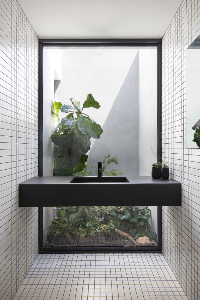 Idee per una stanza da bagno industriale con piastrelle bianche, piastrelle a mosaico, lavabo integrato, pavimento bianco e top nero