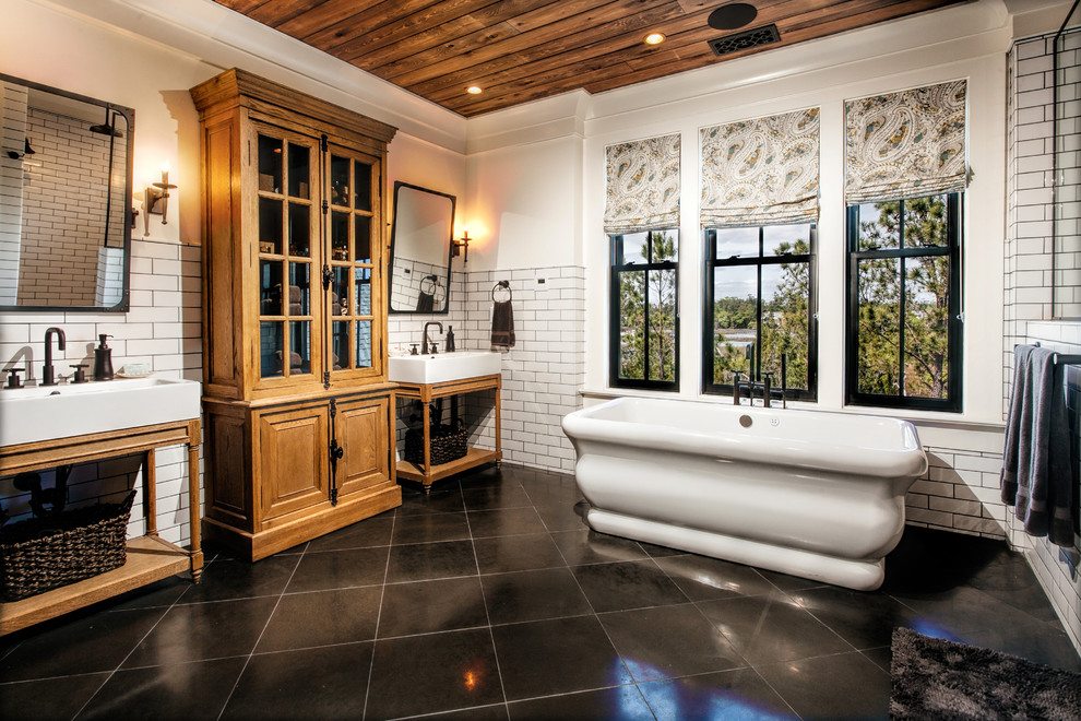 Inspiration för stora klassiska en-suite badrum, med öppna hyllor, ett fristående badkar, vit kakel, tunnelbanekakel, vita väggar, klinkergolv i porslin, ett avlångt handfat, skåp i ljust trä, en hörndusch, en toalettstol med separat cisternkåpa, grått golv och med dusch som är öppen