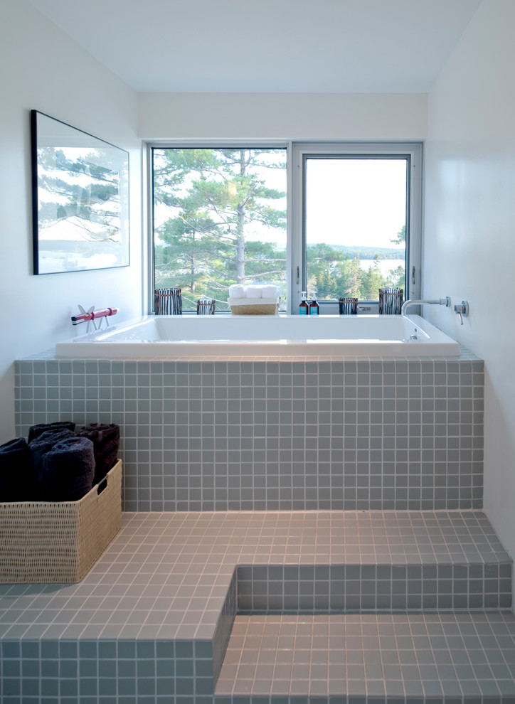 Foto di una stanza da bagno minimalista con vasca ad alcova e piastrelle grigie