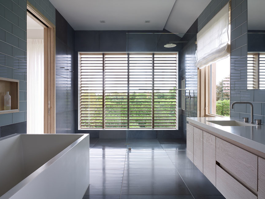 Idee per una grande stanza da bagno padronale design con ante lisce, ante in legno chiaro, vasca freestanding, doccia aperta, piastrelle grigie e lavabo integrato