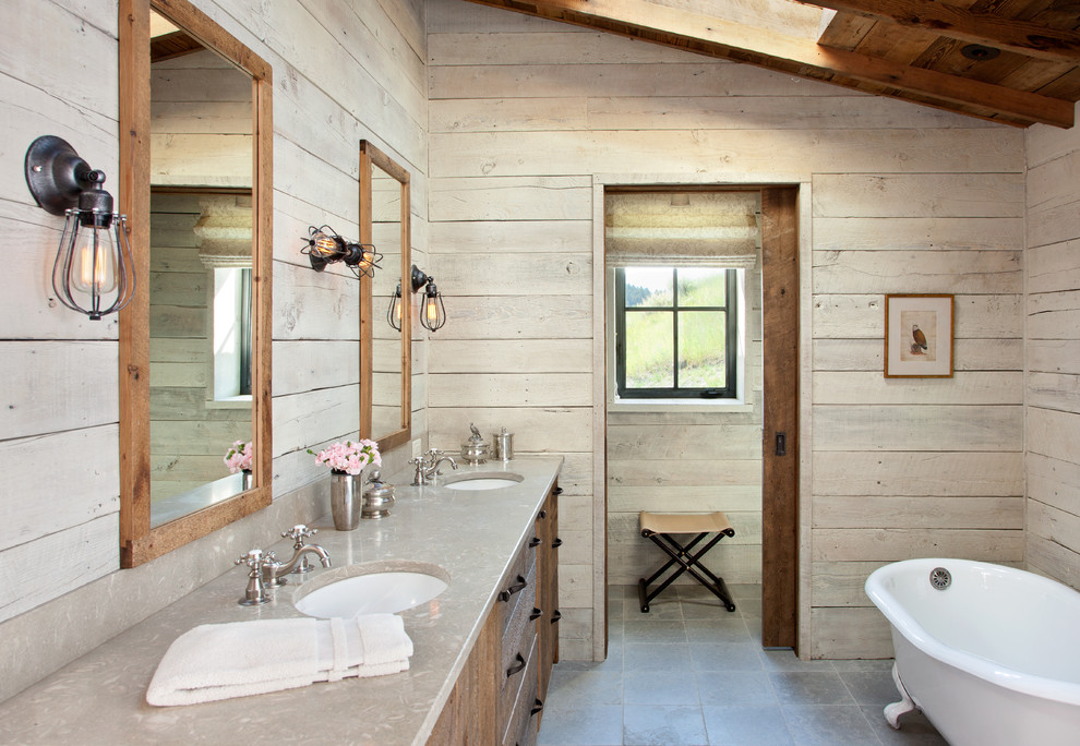 Rustik inredning av ett en-suite badrum, med skåp i mellenmörkt trä, ett badkar med tassar, ett undermonterad handfat och grått golv