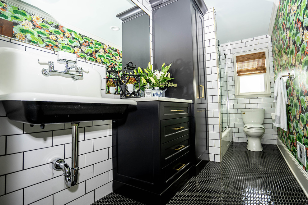 Inspiration for a medium sized bohemian family bathroom in Atlanta with shaker cabinets, black cabinets, an alcove bath, a shower/bath combination, a one-piece toilet, white tiles, ceramic tiles, green walls, ceramic flooring, a wall-mounted sink, engineered stone worktops, black floors, a sliding door and black worktops.