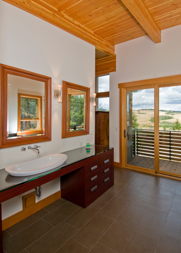 Пример оригинального дизайна: большая главная ванная комната в стиле рустика с настольной раковиной, плоскими фасадами, темными деревянными фасадами, стеклянной столешницей, белыми стенами и полом из керамической плитки