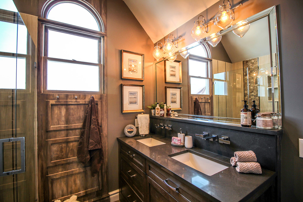 Aménagement d'une grande douche en alcôve classique en bois brun avec un placard avec porte à panneau encastré, un mur gris, un lavabo encastré, un sol en carrelage de porcelaine et une cabine de douche à porte battante.