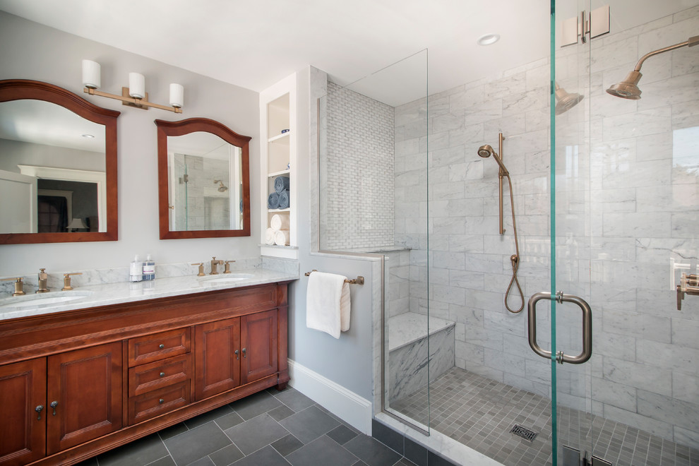 Klassisk inredning av ett mellanstort en-suite badrum, med skåp i mellenmörkt trä, grå kakel, marmorkakel, grå väggar, skiffergolv, ett undermonterad handfat, marmorbänkskiva, grått golv, dusch med gångjärnsdörr och luckor med infälld panel