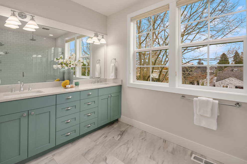 Example of a large transitional master white tile and ceramic tile brown floor and double-sink alcove shower design in Seattle with recessed-panel cabinets, turquoise cabinets, a one-piece toilet, white walls, an undermount sink, a hinged shower door, white countertops and a built-in vanity
