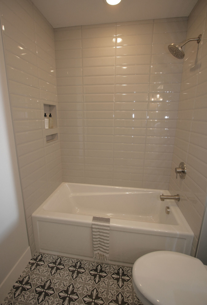 Klassisk inredning av ett litet badrum med dusch, med skåp i shakerstil, vita skåp, ett badkar i en alkov, en dusch i en alkov, en toalettstol med separat cisternkåpa, grå kakel, porslinskakel, grå väggar, klinkergolv i porslin, ett undermonterad handfat, bänkskiva i kvarts, grått golv och dusch med duschdraperi