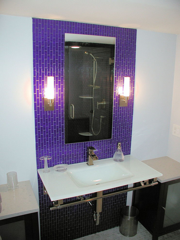 Bild på ett funkis badrum, med ett väggmonterat handfat och luckor med glaspanel