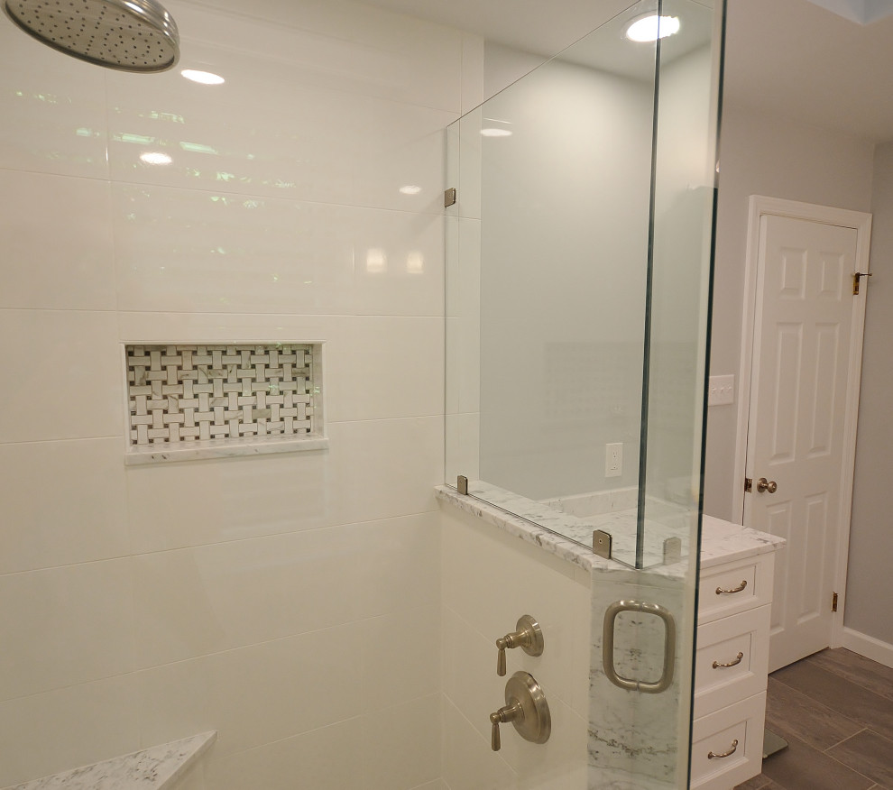 Idéer för att renovera ett stort vintage vit vitt en-suite badrum, med luckor med upphöjd panel, vita skåp, en hörndusch, en toalettstol med hel cisternkåpa, vit kakel, keramikplattor, vita väggar, vinylgolv, ett fristående handfat, marmorbänkskiva, beiget golv och dusch med gångjärnsdörr