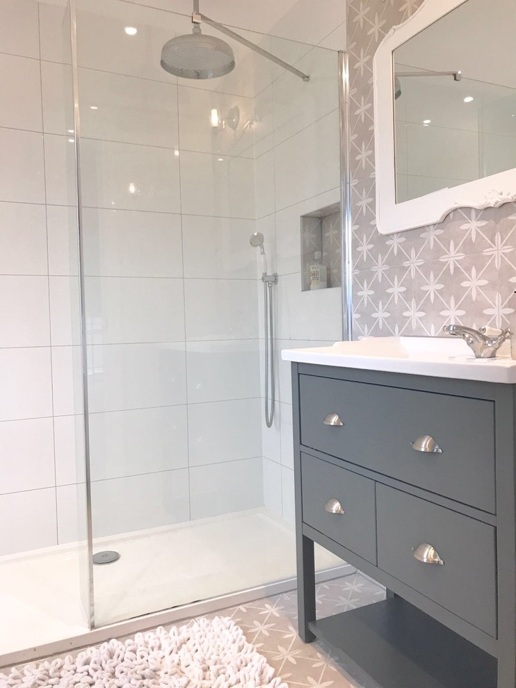 Bild på ett mellanstort skandinaviskt vit vitt en-suite badrum, med grå skåp, grå kakel, cementkakel, vita väggar, cementgolv, grått golv, möbel-liknande, en öppen dusch, ett integrerad handfat och bänkskiva i kalksten