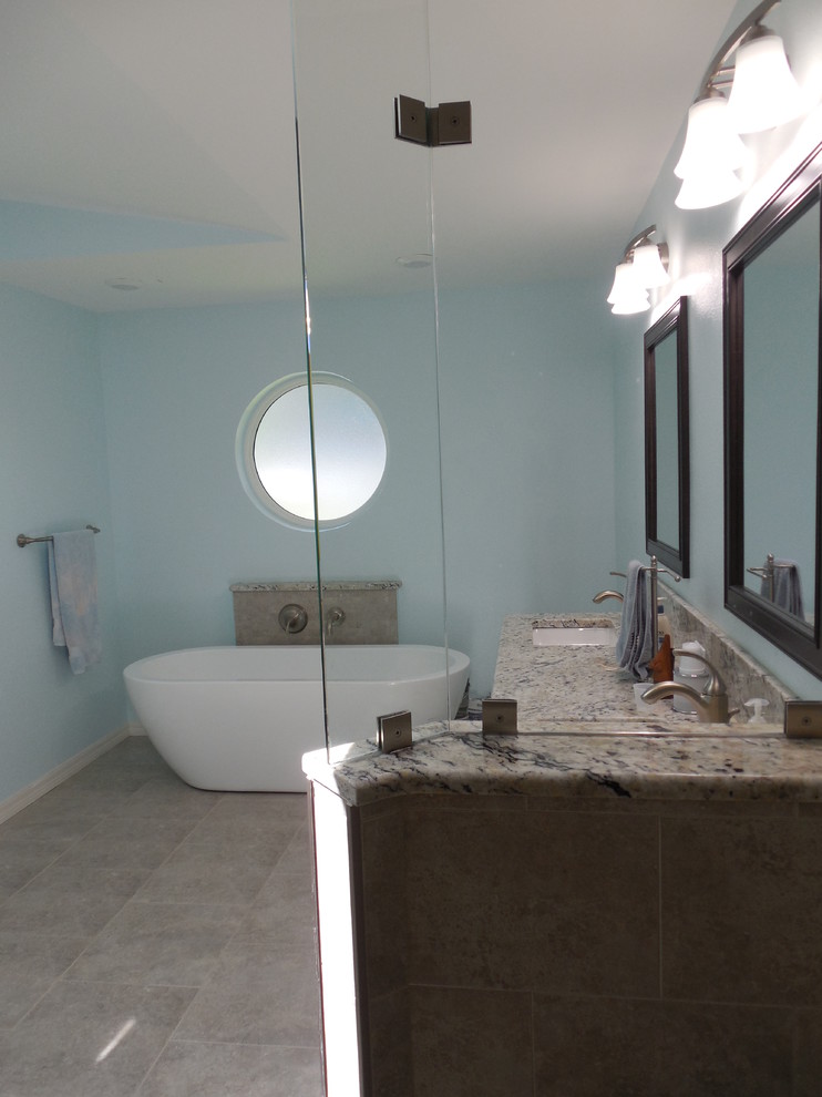 Inspiration för ett mellanstort funkis en-suite badrum, med ett undermonterad handfat, luckor med infälld panel, skåp i mörkt trä, granitbänkskiva, ett fristående badkar, en hörndusch, en bidé, grå kakel, porslinskakel, blå väggar och klinkergolv i porslin