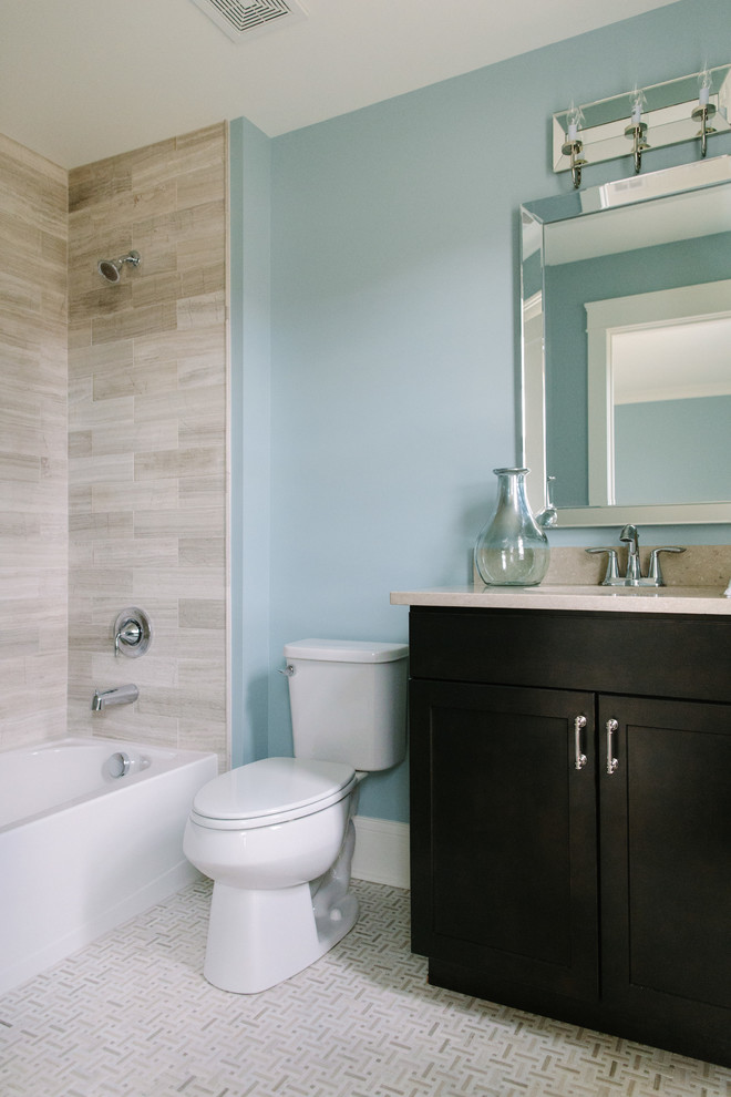 Пример оригинального дизайна: главная ванная комната среднего размера в стиле неоклассика (современная классика) с фасадами в стиле шейкер, темными деревянными фасадами, ванной в нише, душем над ванной, раздельным унитазом, каменной плиткой, синими стенами, врезной раковиной и столешницей из известняка