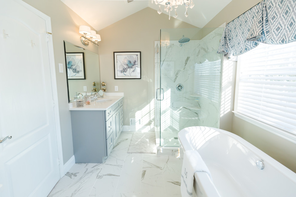 Exemple d'une grande salle de bain principale chic avec un placard à porte shaker, des portes de placard grises, une baignoire indépendante, une douche d'angle, WC séparés, un carrelage blanc, des carreaux de porcelaine, un mur beige, un sol en carrelage de porcelaine, un lavabo encastré et un plan de toilette en quartz modifié.