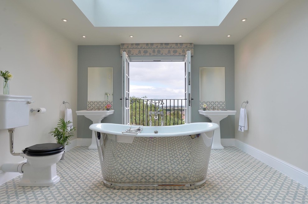 Inspiration for a medium sized traditional family bathroom in London with open cabinets, a freestanding bath, a shower/bath combination, a one-piece toilet, blue tiles, cement tiles, white walls, mosaic tile flooring and a pedestal sink.