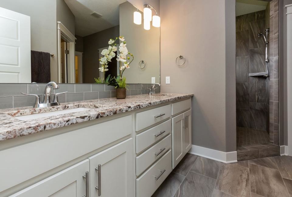Exempel på ett mellanstort modernt en-suite badrum, med ett undermonterad handfat, skåp i shakerstil, vita skåp, granitbänkskiva, ett badkar i en alkov, en dusch/badkar-kombination, en toalettstol med separat cisternkåpa, grå kakel, porslinskakel, grå väggar och klinkergolv i porslin