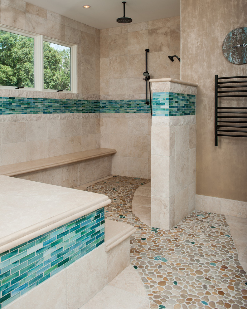 Cette photo montre une grande salle de bain principale méditerranéenne avec une douche ouverte, un carrelage beige, une plaque de galets, un mur beige et un sol en galet.