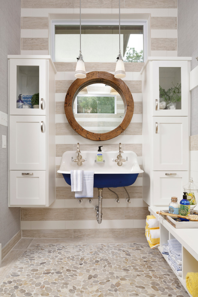 Esempio di una stanza da bagno con doccia stile marinaro di medie dimensioni con lavabo sospeso, ante in stile shaker, ante bianche, pavimento con piastrelle di ciottoli, piastrelle beige, pareti grigie, pavimento beige e top bianco