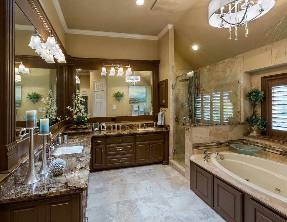 This is an example of a medium sized world-inspired ensuite bathroom in Dallas with raised-panel cabinets, dark wood cabinets, a built-in bath, a corner shower, brown tiles, travertine tiles, beige walls, travertine flooring, a submerged sink, granite worktops, beige floors and a hinged door.