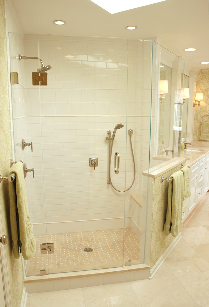 Inredning av ett klassiskt stort en-suite badrum, med ett undermonterad handfat, luckor med infälld panel, vita skåp, laminatbänkskiva, ett fristående badkar, en dusch i en alkov, vit kakel, porslinskakel, vita väggar och marmorgolv