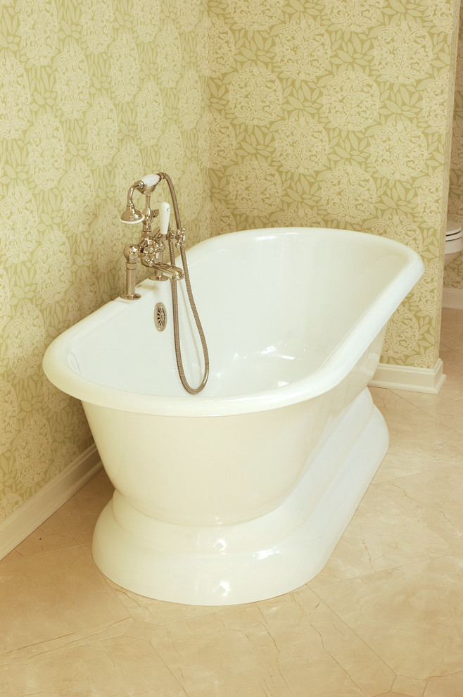 Klassisk inredning av ett stort en-suite badrum, med ett undermonterad handfat, luckor med infälld panel, vita skåp, laminatbänkskiva, ett fristående badkar, vita väggar och marmorgolv