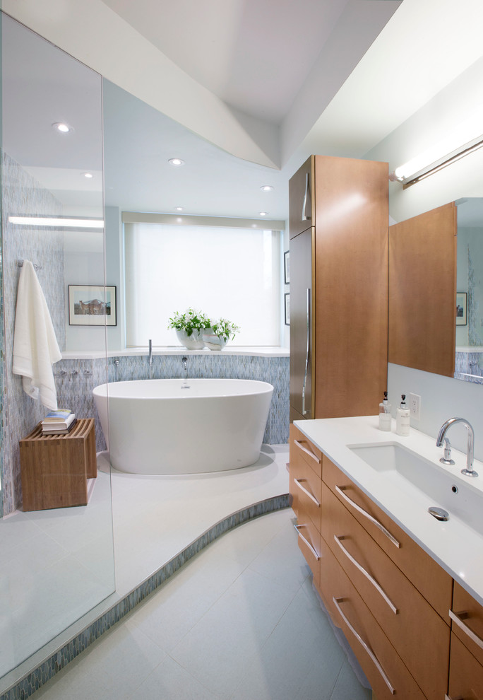Пример оригинального дизайна: главная ванная комната среднего размера в современном стиле с отдельно стоящей ванной, открытым душем, унитазом-моноблоком, стеклянной плиткой, плоскими фасадами, фасадами цвета дерева среднего тона и открытым душем