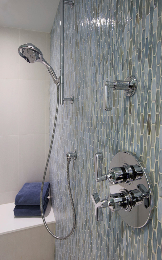 Ejemplo de cuarto de baño principal actual de tamaño medio con bañera exenta, ducha empotrada, sanitario de una pieza, baldosas y/o azulejos azules y baldosas y/o azulejos de vidrio