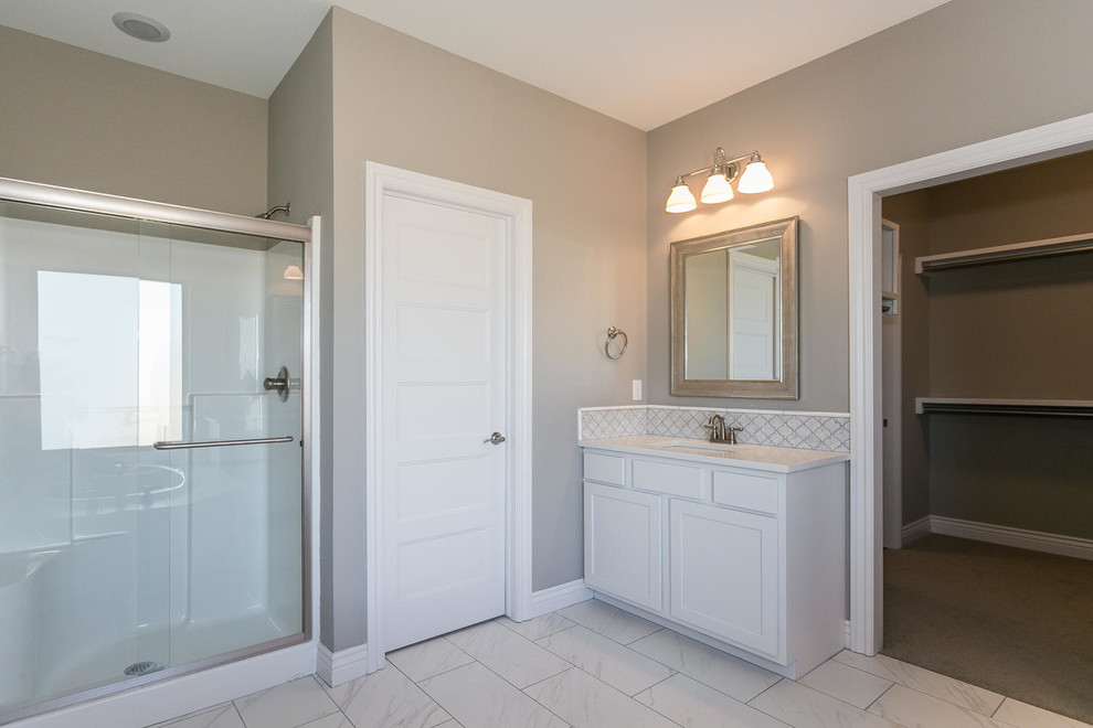 Large contemporary ensuite bathroom in Wichita with a submerged sink, recessed-panel cabinets, white cabinets, granite worktops, a built-in bath, an alcove shower, a one-piece toilet, white tiles, ceramic tiles, beige walls and ceramic flooring.