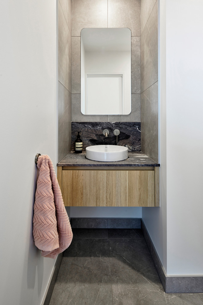 Foto di una stanza da bagno padronale design di medie dimensioni con consolle stile comò, ante in legno chiaro, piastrelle grigie, top in marmo, pavimento grigio, top multicolore, un lavabo e mobile bagno freestanding
