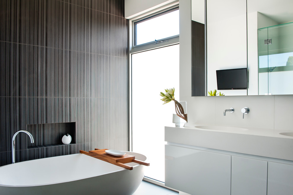 Foto på ett mellanstort funkis en-suite badrum, med ett integrerad handfat, släta luckor, vita skåp, bänkskiva i kvarts, ett fristående badkar, en dusch i en alkov, svart kakel, porslinskakel, svarta väggar och klinkergolv i porslin