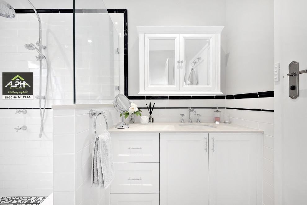 Large victorian ensuite wet room bathroom in Sydney with shaker cabinets, white cabinets, a freestanding bath, a two-piece toilet, black and white tiles, porcelain tiles, grey walls, porcelain flooring, a submerged sink, engineered stone worktops, black floors, a hinged door and white worktops.