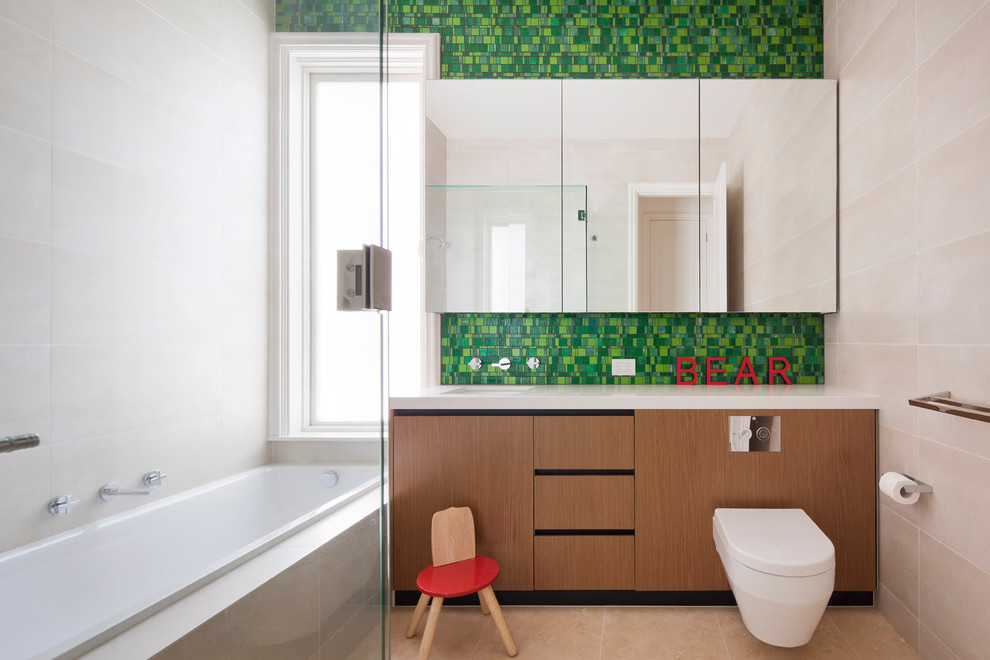 Foto på ett funkis badrum för barn, med en vägghängd toalettstol, grön kakel och mosaik
