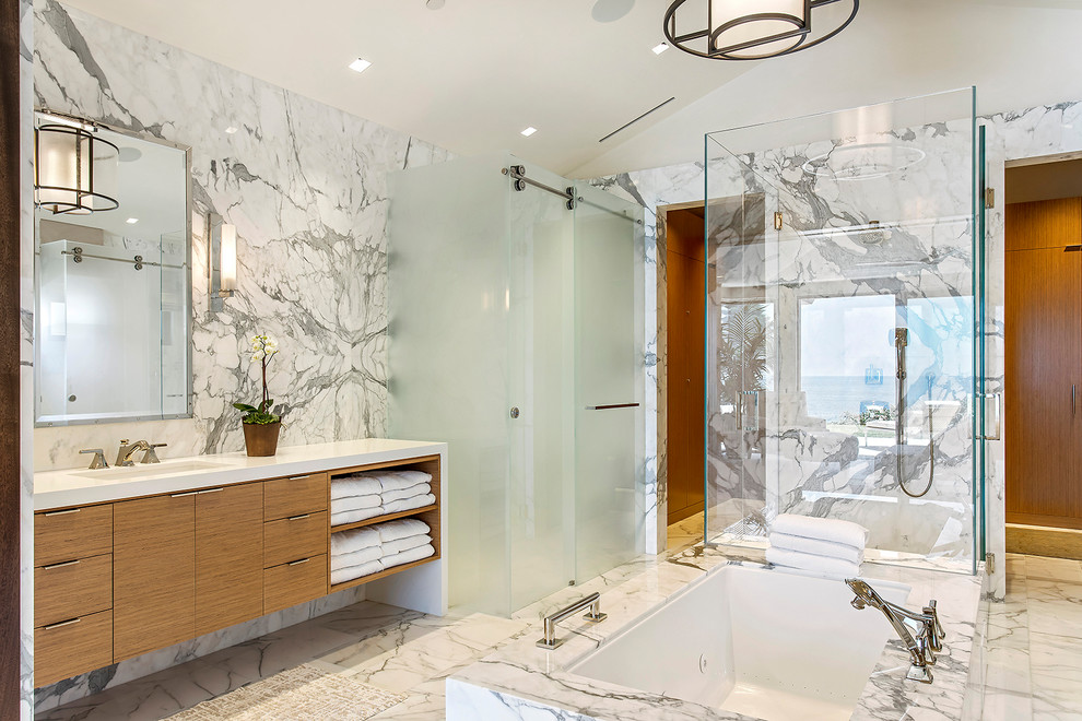 Idéer för mycket stora funkis vitt en-suite badrum, med släta luckor, marmorkakel, marmorgolv, ett undermonterad handfat, skåp i ljust trä, ett fristående badkar, en dubbeldusch, vit kakel, vita väggar, marmorbänkskiva, vitt golv och dusch med skjutdörr