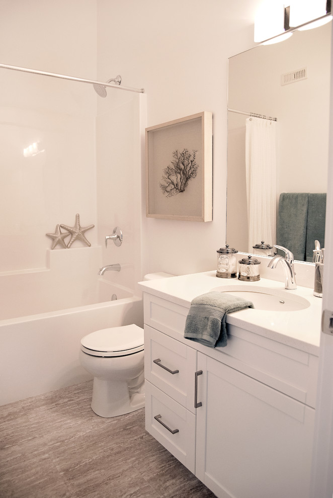 Ejemplo de cuarto de baño actual de tamaño medio con armarios estilo shaker, puertas de armario blancas, paredes blancas, lavabo bajoencimera, encimera de cuarcita, suelo gris y ducha con cortina