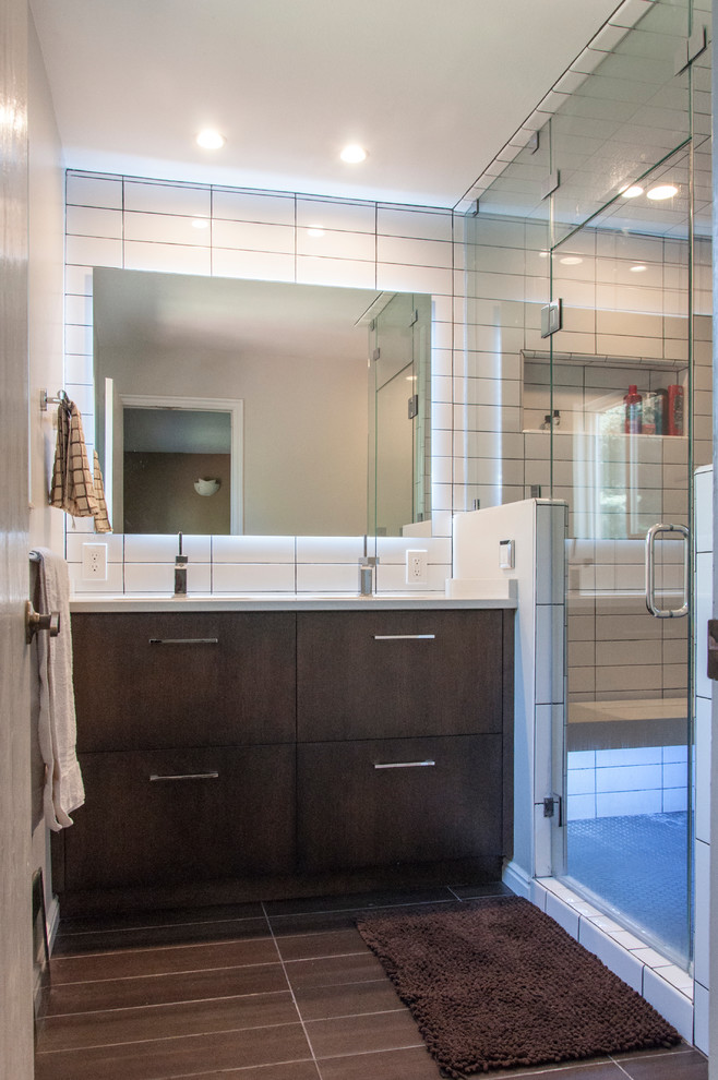 This is an example of a small contemporary ensuite bathroom in Salt Lake City with flat-panel cabinets, dark wood cabinets, a corner shower, ceramic tiles, a submerged sink, engineered stone worktops, porcelain flooring, brown floors and a hinged door.