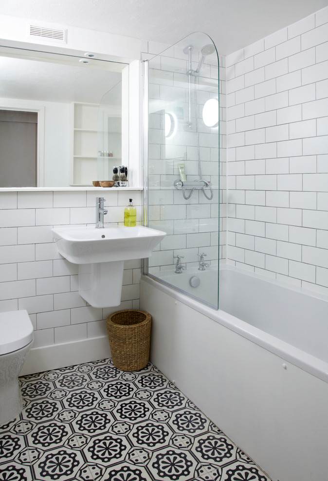 Идея дизайна: маленькая ванная комната в стиле неоклассика (современная классика) с подвесной раковиной, душем над ванной, унитазом-моноблоком, белой плиткой, плиткой кабанчик, белыми стенами и ванной в нише для на участке и в саду