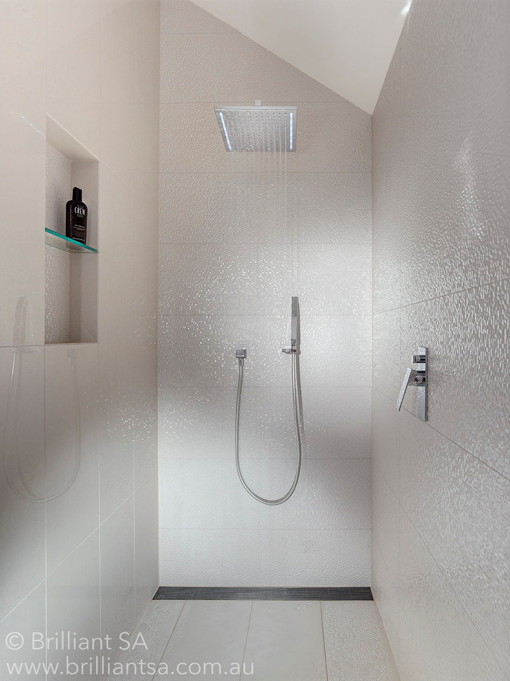 Imagen de cuarto de baño actual pequeño con ducha esquinera, baldosas y/o azulejos blancos, baldosas y/o azulejos de cemento, paredes blancas, suelo de baldosas de cerámica y aseo y ducha
