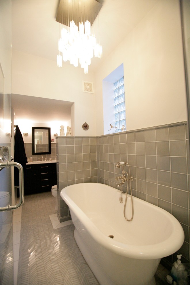 ニューヨークにあるコンテンポラリースタイルのおしゃれなマスターバスルーム (フラットパネル扉のキャビネット、濃色木目調キャビネット、置き型浴槽、アルコーブ型シャワー、一体型トイレ	) の写真
