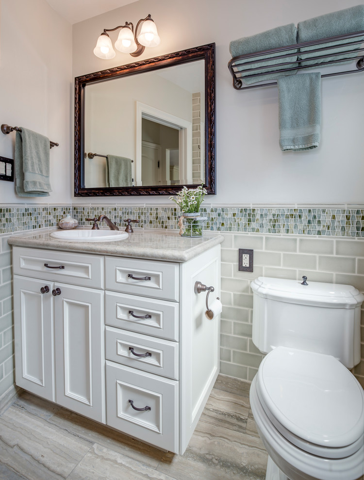Пример оригинального дизайна: маленькая ванная комната в классическом стиле с белыми фасадами, разноцветной плиткой, серой плиткой, стеклянной плиткой, белыми стенами, душевой кабиной, фасадами с утопленной филенкой, накладной раковиной и серой столешницей для на участке и в саду