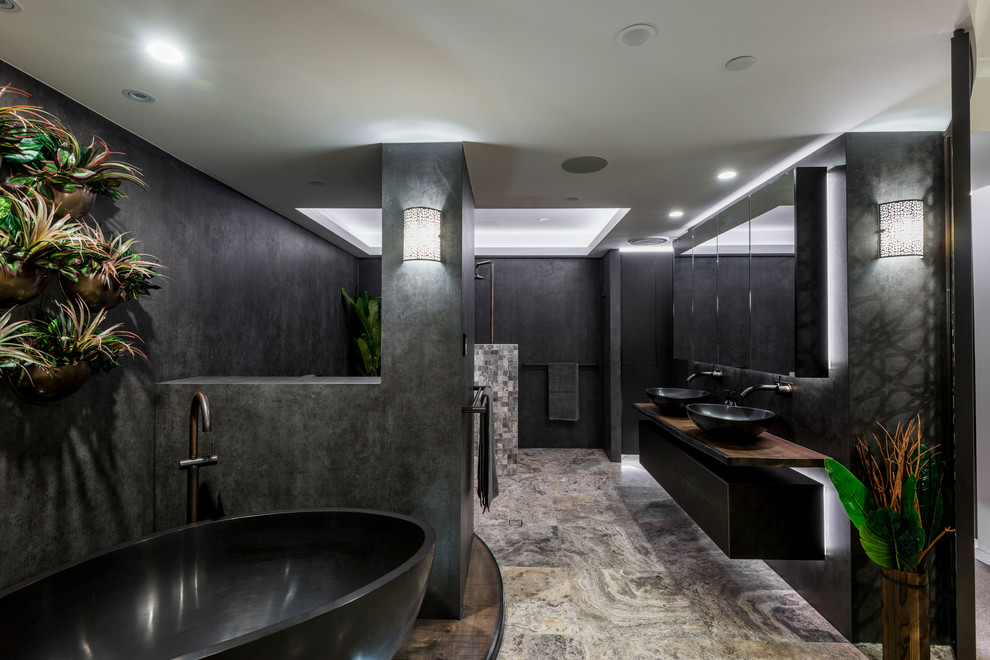 Inspiration for a large contemporary master gray tile and porcelain tile travertine floor and beige floor bathroom remodel in Brisbane with furniture-like cabinets, dark wood cabinets, a wall-mount toilet, gray walls, a vessel sink and wood countertops
