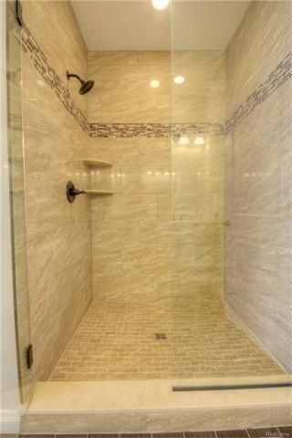 Exempel på ett stort klassiskt en-suite badrum, med luckor med infälld panel, vita skåp, ett platsbyggt badkar, en dubbeldusch, en toalettstol med hel cisternkåpa, beige kakel, stenkakel, grå väggar, klinkergolv i keramik, ett undermonterad handfat och kaklad bänkskiva