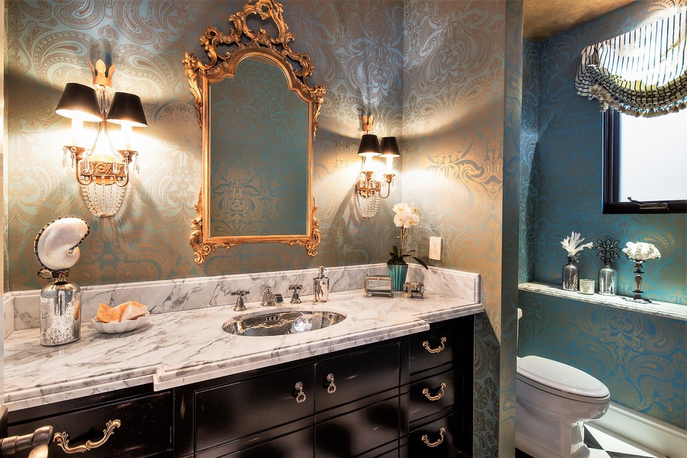 This is an example of a medium sized eclectic bathroom with freestanding cabinets, black cabinets, blue walls, marble flooring, a submerged sink and marble worktops.