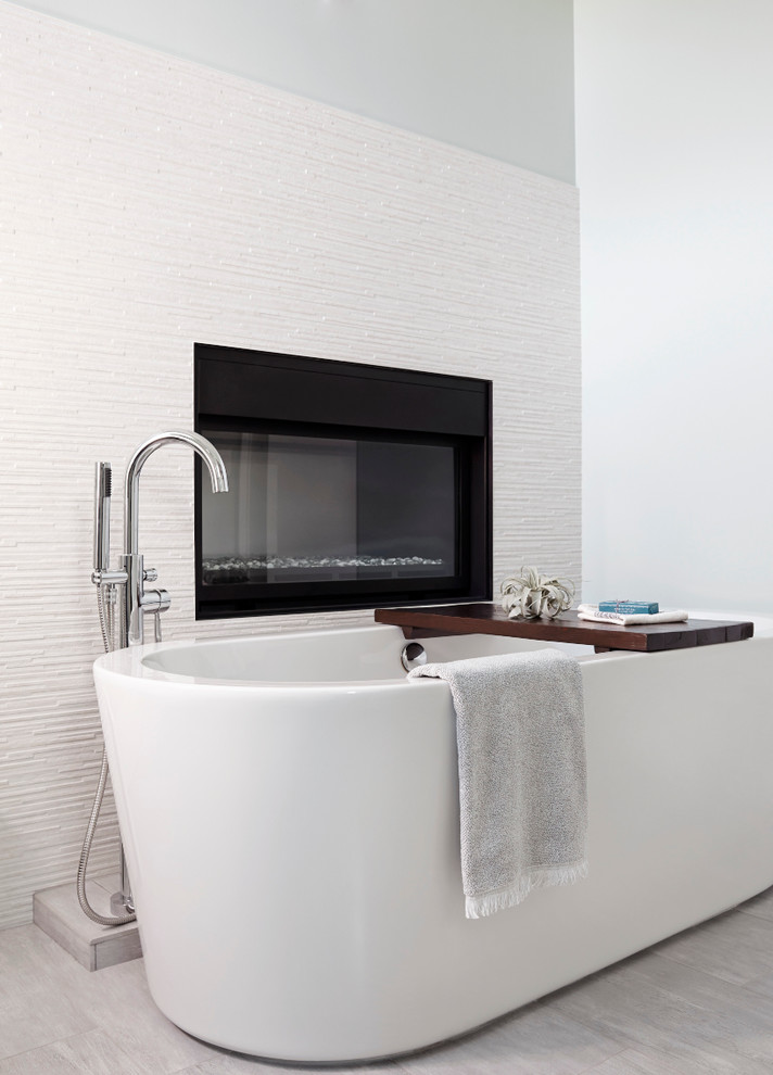 This is an example of a contemporary bathroom in San Francisco with a freestanding bath, white tiles and white walls.