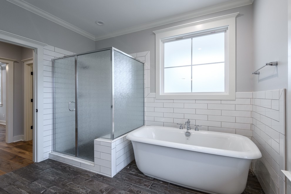 Exempel på ett mellanstort lantligt flerfärgad flerfärgat en-suite badrum, med vita skåp, ett fristående badkar, en hörndusch, vit kakel, keramikplattor, grå väggar, klinkergolv i keramik, granitbänkskiva, brunt golv, dusch med gångjärnsdörr, luckor med infälld panel, en toalettstol med separat cisternkåpa och ett undermonterad handfat
