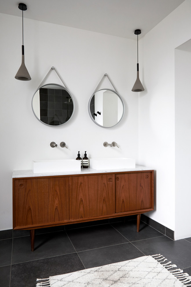 Exempel på ett stort nordiskt vit vitt en-suite badrum, med ett fristående badkar, en öppen dusch, vita väggar, klinkergolv i keramik, ett fristående handfat, marmorbänkskiva, svart golv, med dusch som är öppen, släta luckor och bruna skåp