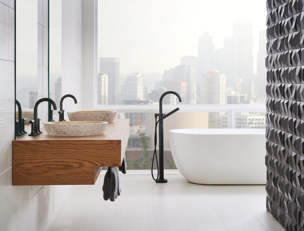 This is an example of a medium sized contemporary bathroom in Other with medium wood cabinets, a freestanding bath, black and white tiles, porcelain tiles, white walls, porcelain flooring, a vessel sink, wooden worktops and white floors.
