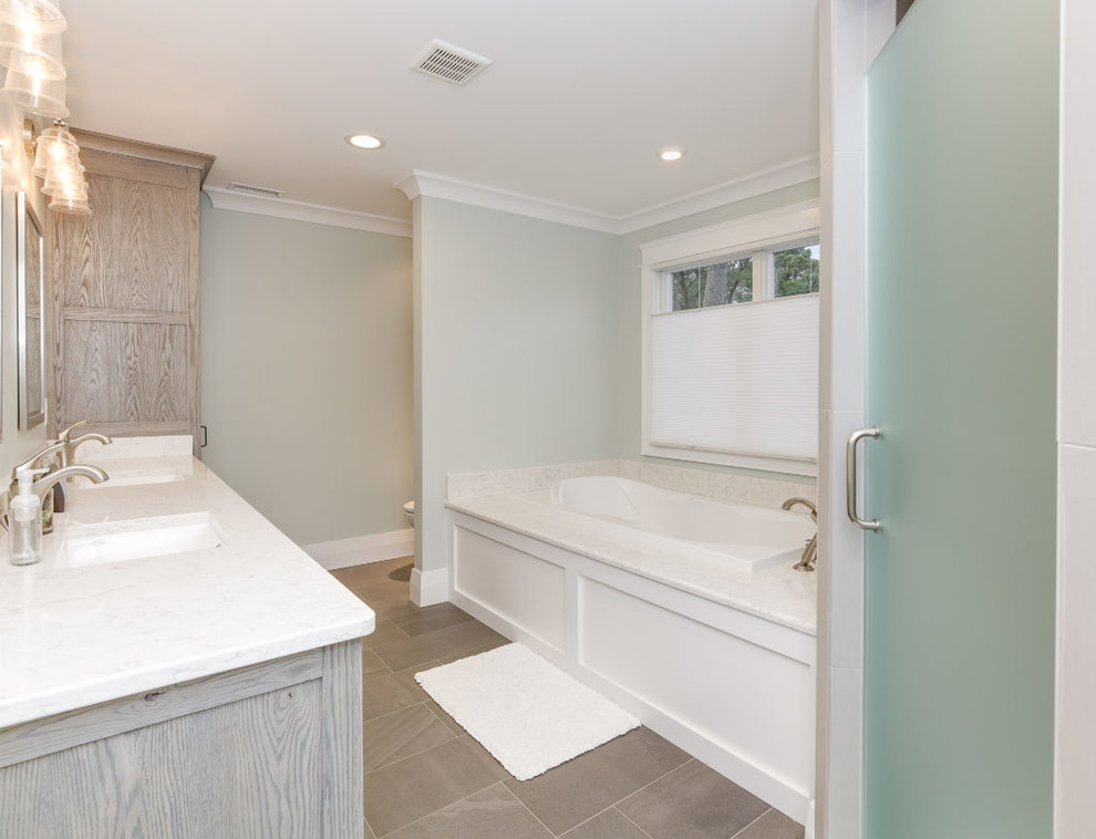 Idéer för amerikanska en-suite badrum, med skåp i slitet trä, ett badkar i en alkov, en toalettstol med hel cisternkåpa, porslinskakel, gröna väggar, klinkergolv i porslin och ett konsol handfat