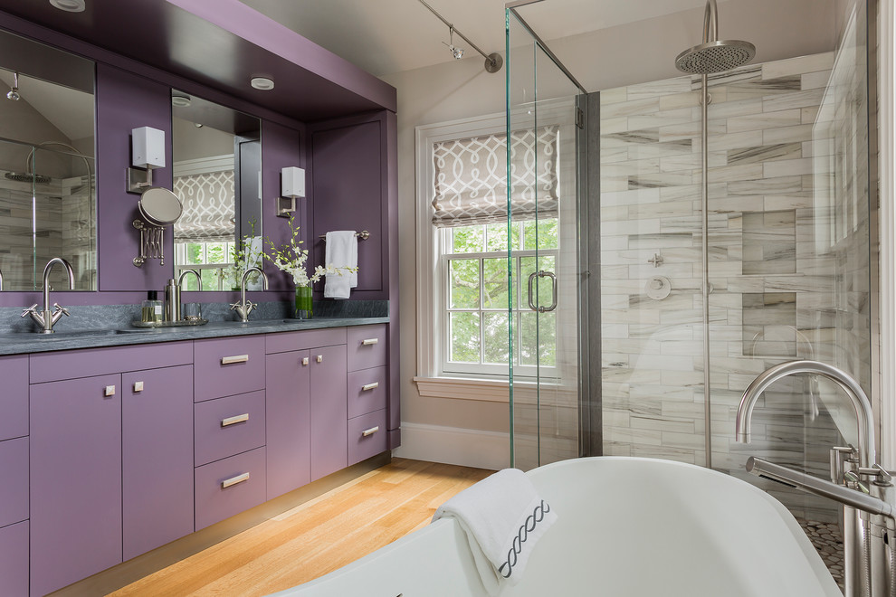 Cette image montre une grande salle de bain principale design avec un lavabo encastré, une baignoire indépendante, une douche d'angle, un mur gris, parquet clair et un carrelage gris.