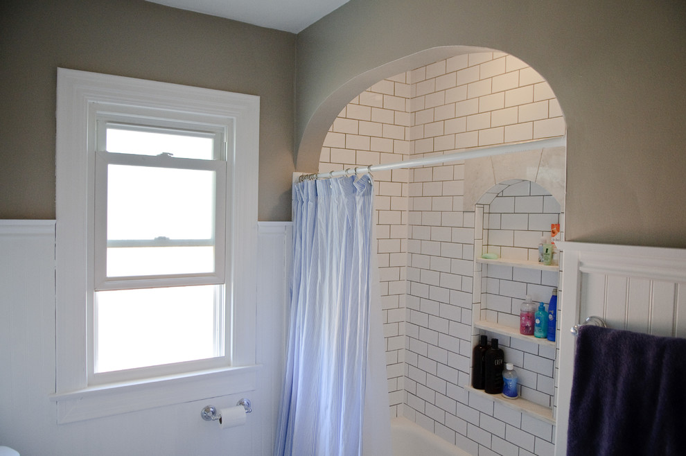 Photo of a small country bathroom in Indianapolis with a pedestal sink, flat-panel cabinets, white cabinets, a built-in bath, a shower/bath combination, white tiles, ceramic tiles and marble flooring.