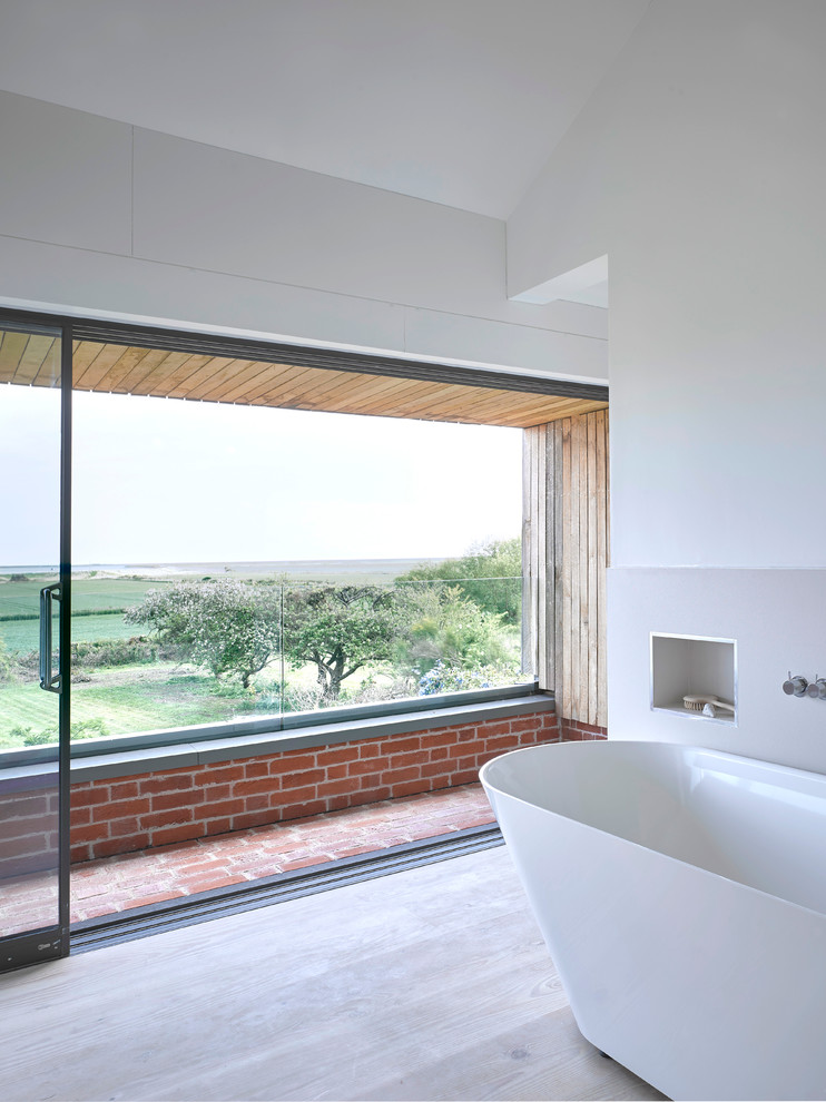 Пример оригинального дизайна: главная ванная комната среднего размера в современном стиле с отдельно стоящей ванной, белой плиткой, белыми стенами и светлым паркетным полом