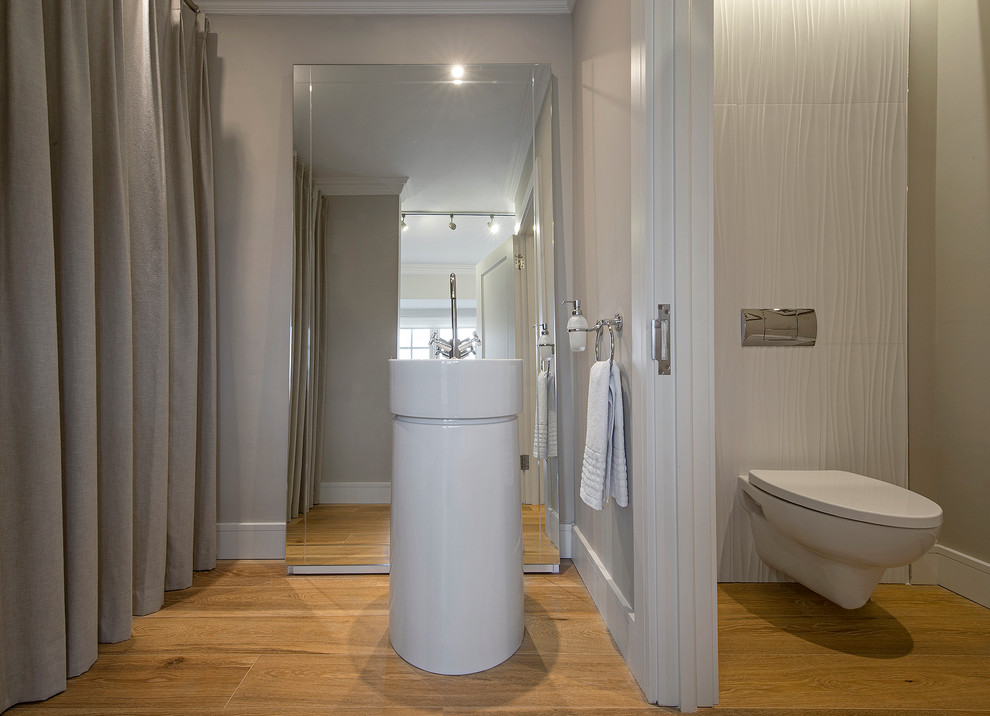 This is an example of a traditional bathroom in Dublin with freestanding cabinets, white cabinets, a freestanding bath, white tiles and ceramic tiles.